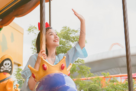 海盗旅游青年女性假期游乐场玩旋转木马背景