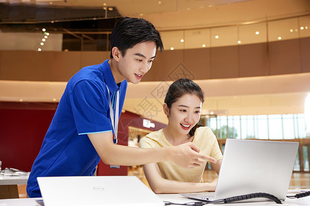 服务学生素材数码店销售员向顾客推销笔记本电脑背景