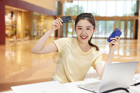 手拿银行卡开心购物的大学生高清图片