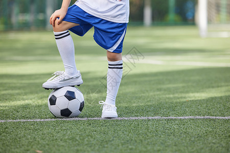 运动制服踢足球的小男孩脚部特写背景