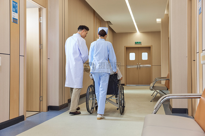 医生护士推坐轮椅的病人患者背影图片