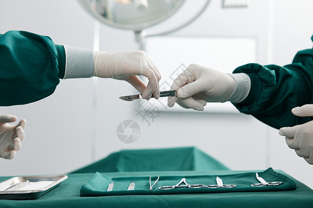 外科医生传递手术刀特写高清图片