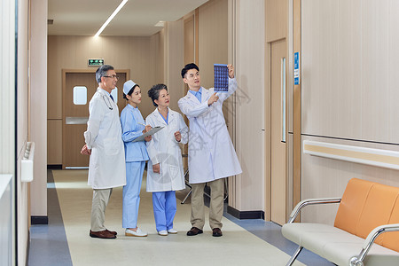 医疗医生护士团队走廊里探讨X光片背景图片