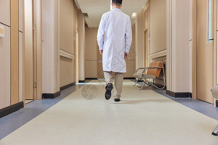 医院走廊男性医生走向手术室背影背景图片
