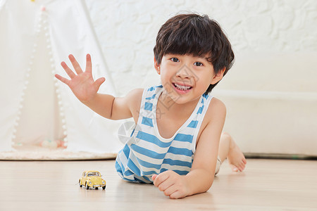 玩具车素材小男孩趴在地板上玩玩具车背景