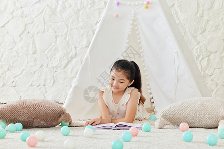 小女孩在儿童帐篷里看书高清图片