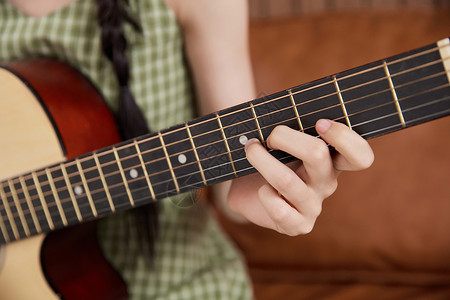 女性弹奏吉他手部特写图片