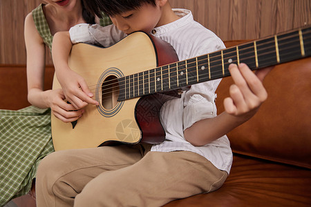 音乐教师教儿童弹奏吉他特写图片