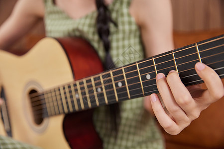 吉他老师女性弹奏吉他手部特写背景