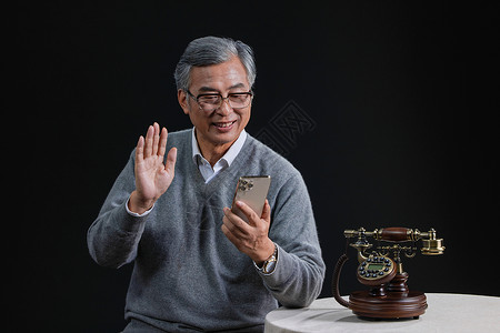 空巢老人拿手机和亲人视频聊天背景图片