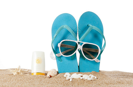 沙滩包沙滩上的拖鞋墨镜和防晒霜背景