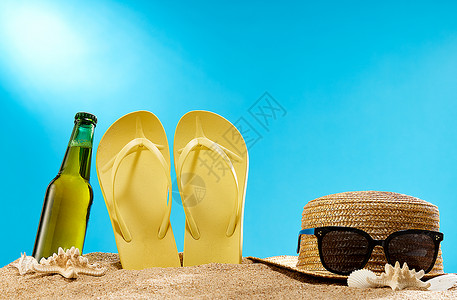 沙滩上的拖鞋夏天沙滩上的啤酒和防晒霜背景