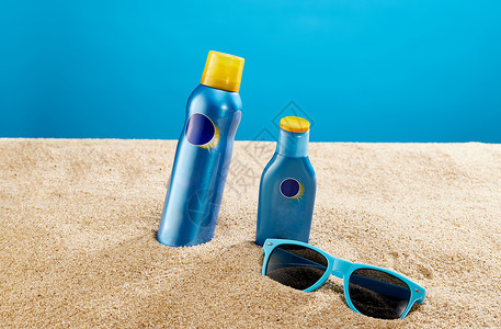 夏日沙滩用品沙滩上的墨镜和防晒用品背景