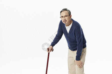 老年男性拄着拐杖膝盖疼背景图片