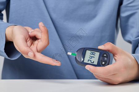温度检测男性使用血糖测试仪背景