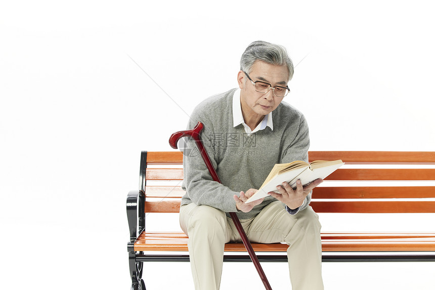 老年男性坐长椅上阅读图片