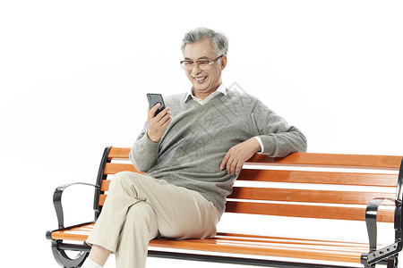 老年男性坐在椅子上玩手机图片