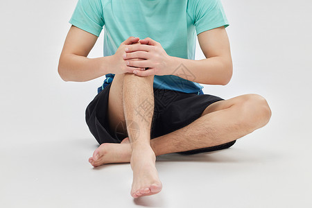 膝盖交叉双腿运动健身男性按摩膝盖关节特写背景