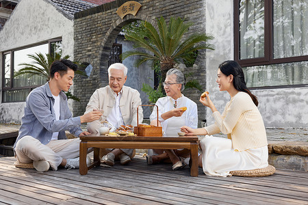 一家人中秋节庭院相聚吃月饼高清图片