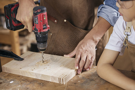 暑期班培训传单木工师傅使用手电钻特写背景