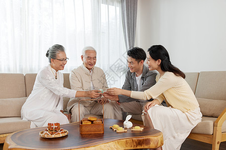 吃月饼的一家人新婚夫妇和爸妈相聚过中秋节吃月饼背景