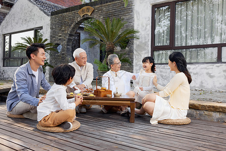中秋相聚一家人庭院里相聚过中秋节吃月饼背景