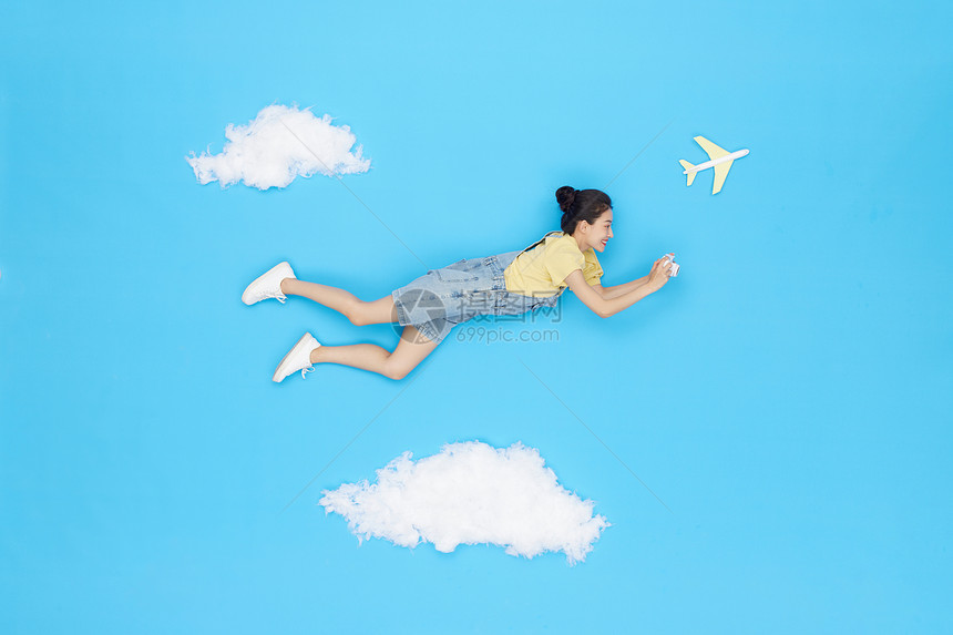 创意俯拍美女云朵上飞行旅行图片