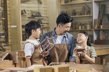 木匠师傅带着小朋友体验木工课背景图片