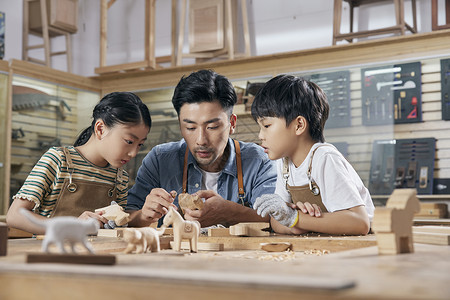 木工老师教小朋友木块雕刻高清图片