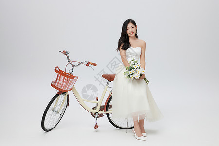 爱心花束穿着婚纱的女性坐在自行车上背景