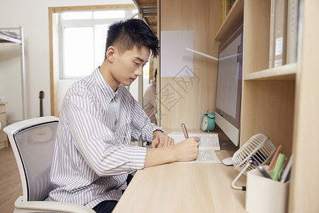 宿舍写论文的大学男青年背景图片