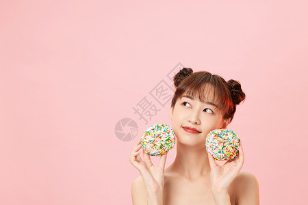 粉红少女心手拿甜甜圈展示的元气美女背景