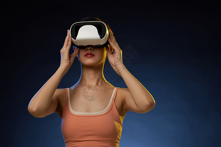 橙色蓝色科技带着VR眼镜打虚拟游戏的女青年背景