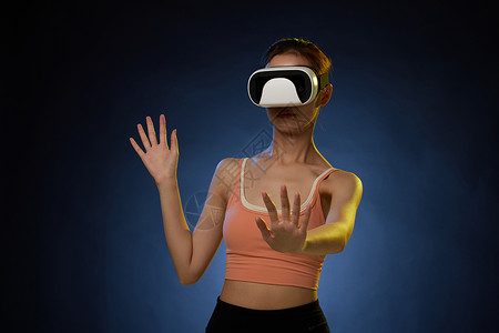 带着VR眼镜打虚拟游戏的女青年图片