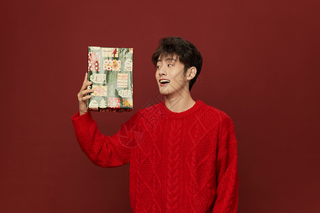 圣诞男生素材韩系男生手拿圣诞礼物盒背景
