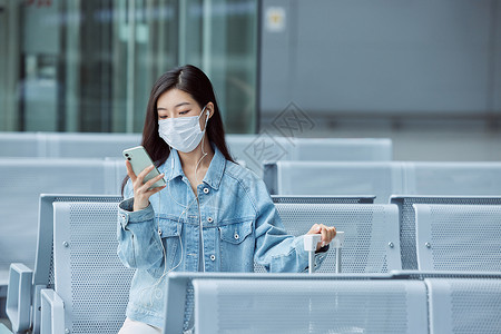 医疗旅游机场候机厅戴口罩的女性看手机背景