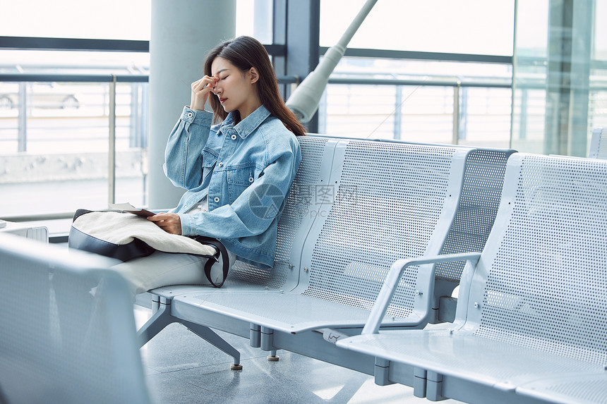 在机场候机厅疲劳难过的女性图片