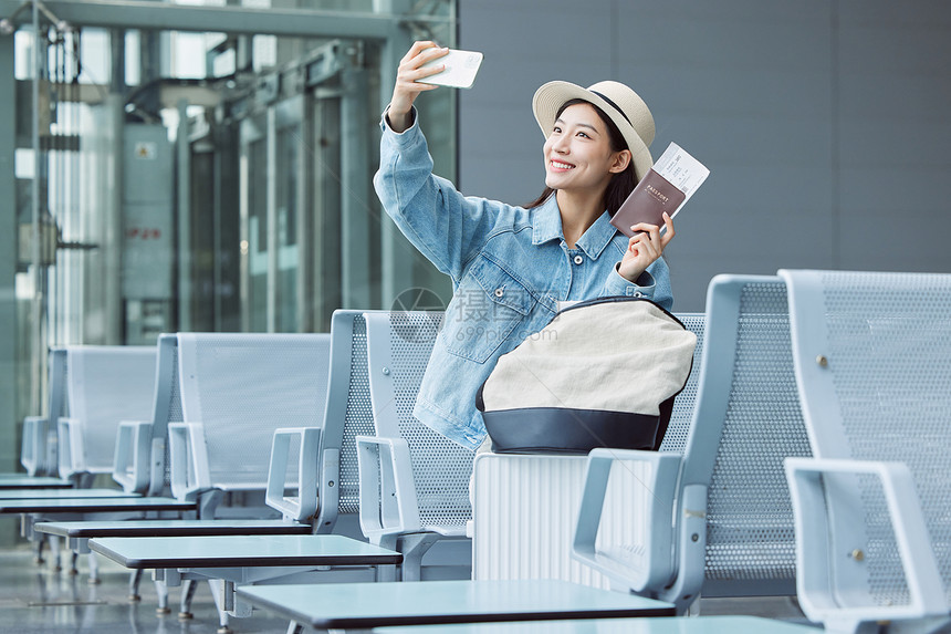 旅游出行的年轻女性手拿机票和护照图片