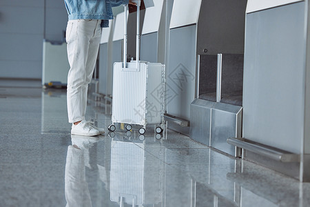 旅行出行的女性在机场托运行李脚部特写图片