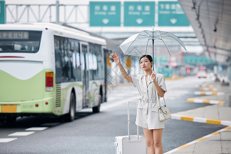 撑着伞在路边打车的商务女性高清图片