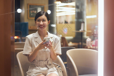 咖啡店内使用手机的商务女性背景图片
