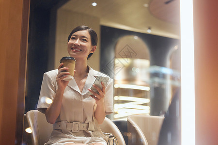 小资餐厅咖啡店内使用手机的商务女性背景