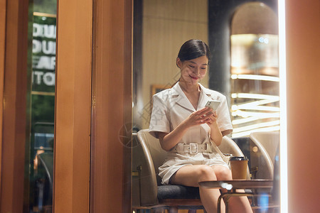 咖啡店内使用手机的商务女性高清图片