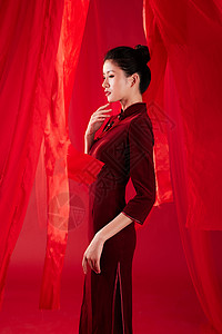 红色飘带背景中的旗袍美女图片