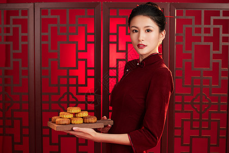 喜庆中秋端着一叠月饼的旗袍美女背景