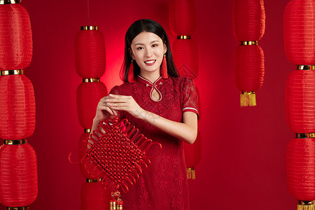拿着中国结的旗袍女子拜年图片