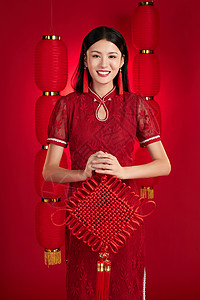 穿旗袍的年轻女子拿着中国结拜年高清图片