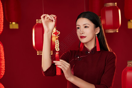 拿着中国结装饰物的旗袍女子图片