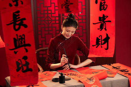 中国红毛笔字体用毛笔写春联的旗袍美女背景
