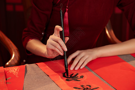 节日手写毛笔字旗袍美女在写对联背景